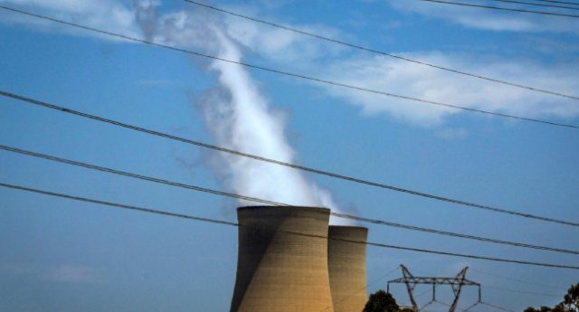 FILES-This-file-photo-taken-on-December-13-2023-shows-electricity-lines-near-emission-funnels-for