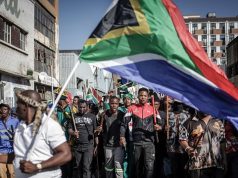 Xenophobia: FG Urges South Africa To Take Concrete Action Against Attacks On Nigerians Protesters hold sticks and flags while chanting slogans as they march during a demonstration by the "March and March" and Operation Dudula movements marking an unofficial deadline set by citizen-led groups for undocumented foreign nationals to leave South Africa, in Johannesburg, on June 30, 2026. South African police deployed to head off unrest and protests on June 30, 2026, the unofficial deadline set by anti-immigrant groups for undocumented foreign nationals to leave that has already pushed thousands to flee. Officers were out in force to prevent violence and looting by the xenophobic groups, while hundreds of foreign nationals took refuge in several cities, urgently seeking help to leave. (Photo by EMMANUEL CROSET / AFP)